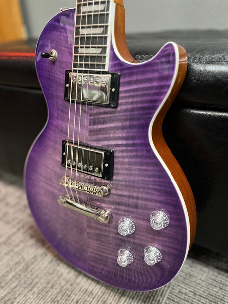 a purple guitar sitting on top of a black case