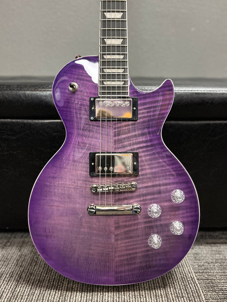 a purple guitar sitting on top of a carpet