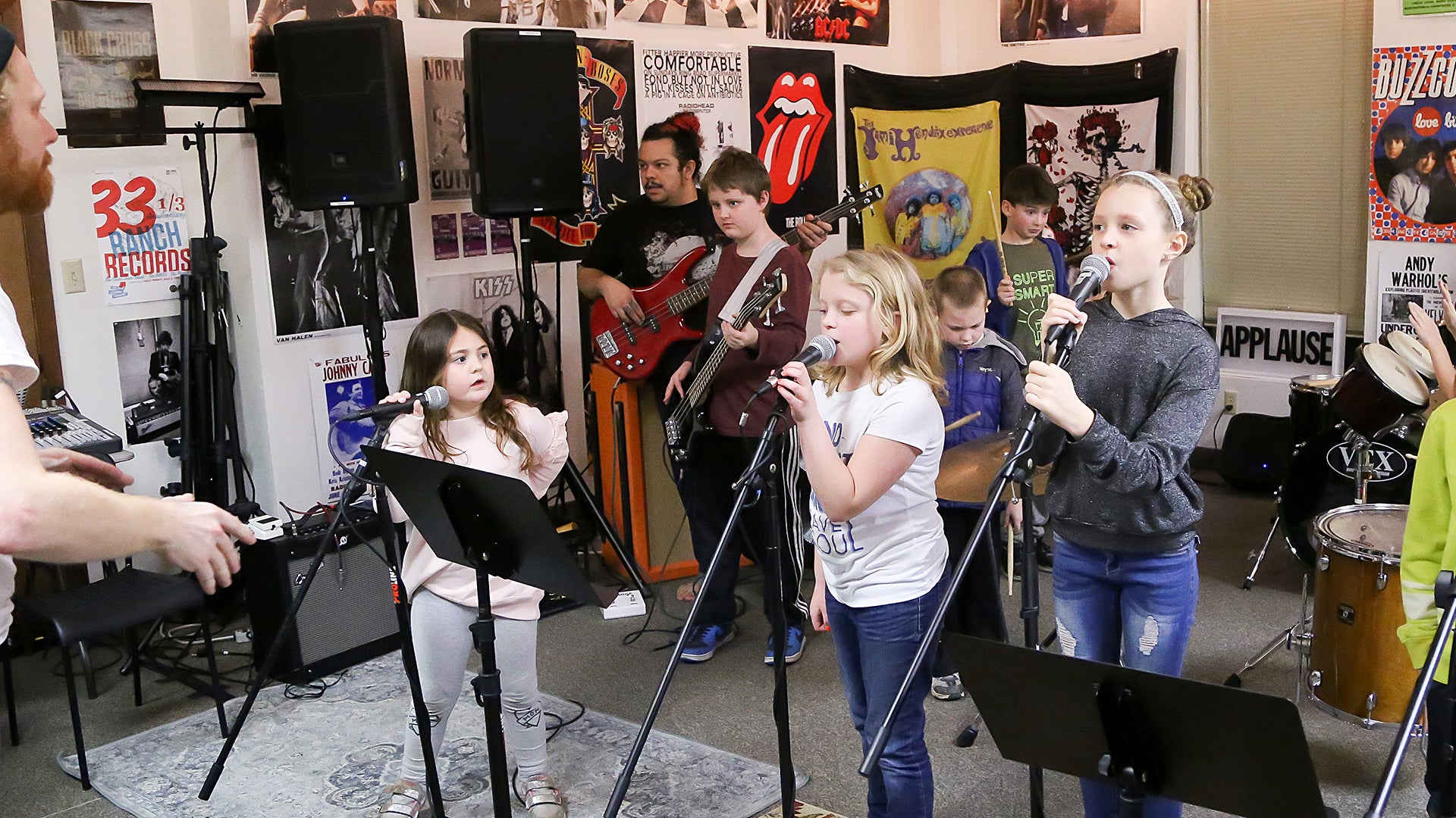 A group of young rockers age 8 -11. They are performing an indoor show.